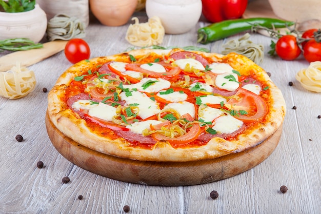 italian pizza on a wooden background with decoration around