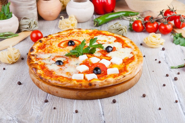 italian pizza on a wooden background with decoration around