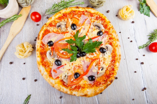 italian pizza on a wooden background with decoration around