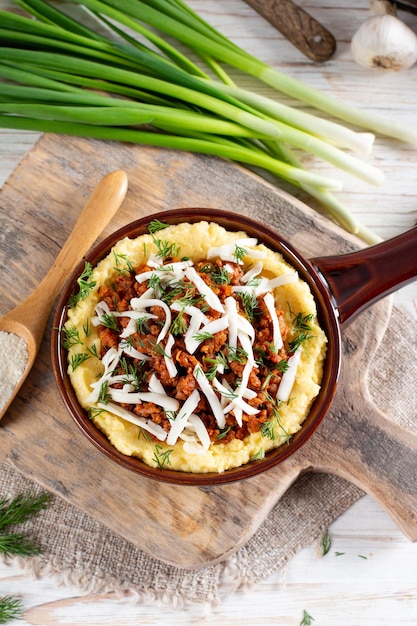 Italian polenta with ragu bolognese on a white wooden table