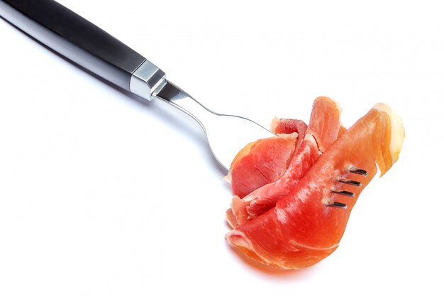 Italian prosciutto crudo or spanish ham on fork