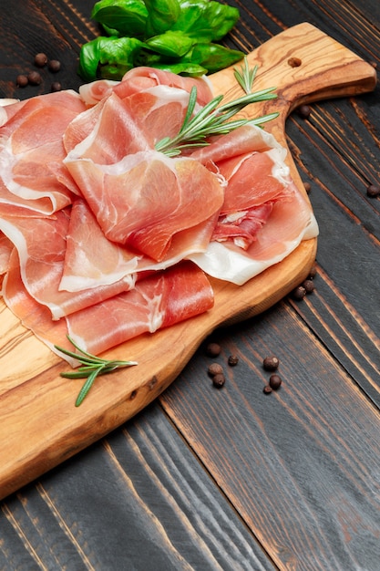 Italian prosciutto crudo or spanish ham. Raw ham on wooden surface