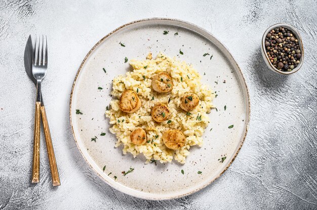 Italian Risotto with pan seared sea scallops. White background. Top view.