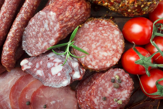 Italian salami with red pepper cherry tomatoes on a wooden background