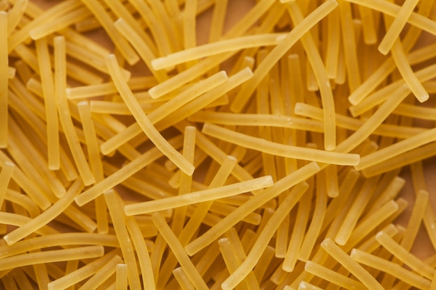 Italian short thin vermicelli on the whole background. Close-up, layout for a grocery store, menu, recipes, pasta packs