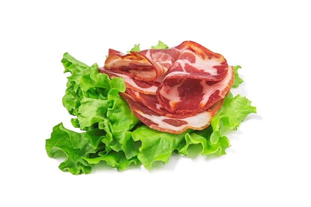 Italian sliced dried coppa with spices with lettuce leaf isolated on white background