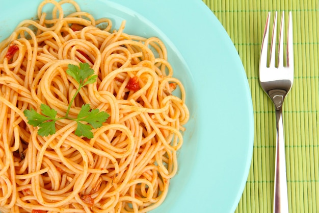 Italian spaghetti in plate on bamboo mat closeup