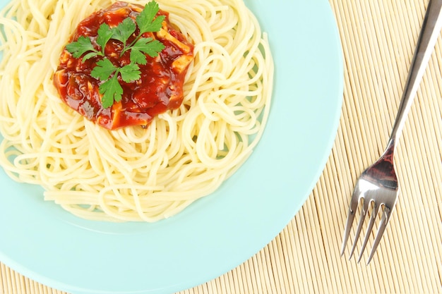 Italian spaghetti in plate on bamboo mat