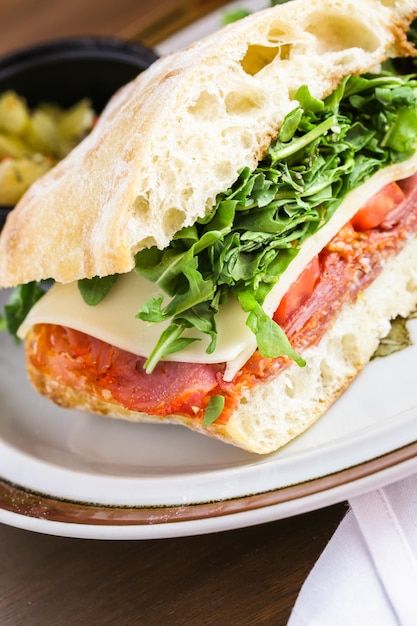 Italian sub sandwich with arugula on ciabatta bread.