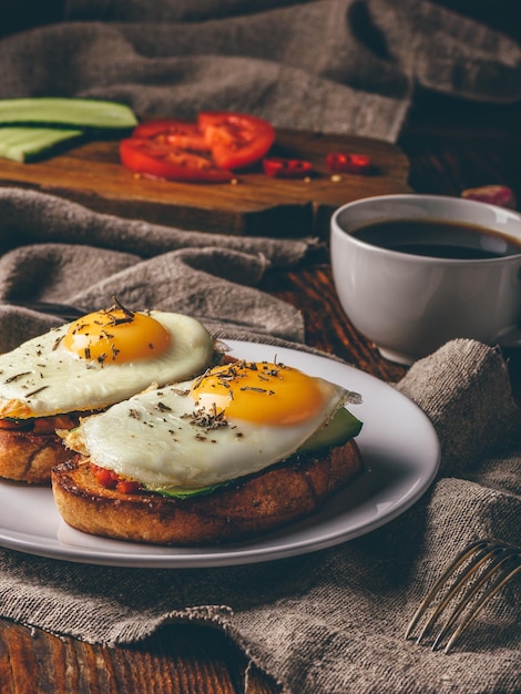 Italian toasts with vegetables and fried eggs with cup of coffee