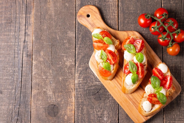 Italian tomato and cheese bruschetta Tapas antipasti with chopped vegetables herbs and oil on grilled ciabatta and baguette bread