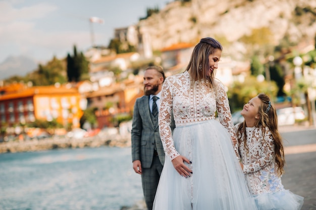 Italy, Lake Garda. Beautiful family on the shores of lake Garda in Italy at the foot of the Alps. Father, mother and daughter in Italy.