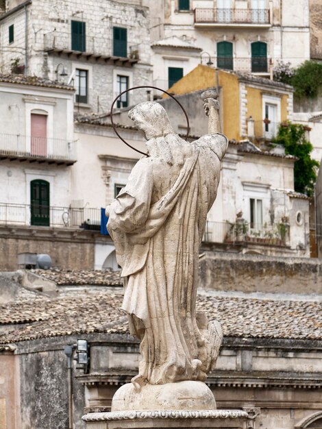 Italy Sicily Modica Ragusa Province St Peter's Cathedral statue and old buildings in the background