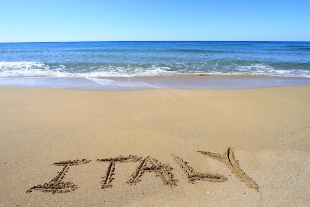 Italy written on sandy beach