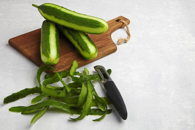 Ith skin and knife on a brown wooden cutting board on a light gray concrete table