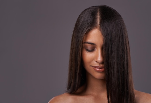 Its her crowning glory A young woman with sleek hair posing in studio