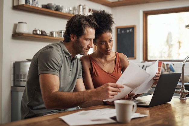 Its never too late to start Cropped shot of a couple using their laptop and going through paperwork at home