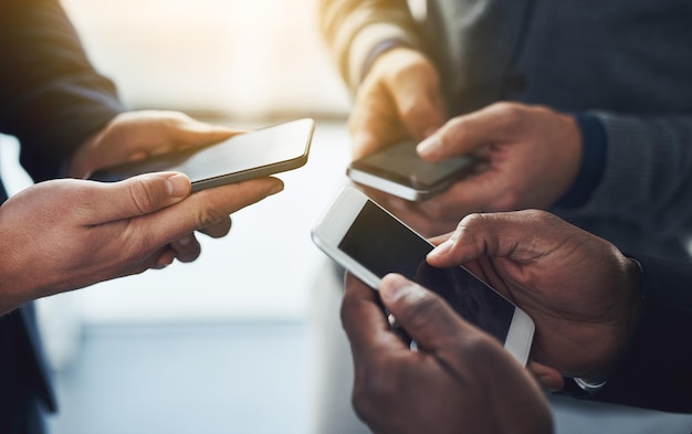 Its vital to stay updated in a connected world Shot of a group of unrecognisable businesspeople using their cellphones in synchronicity