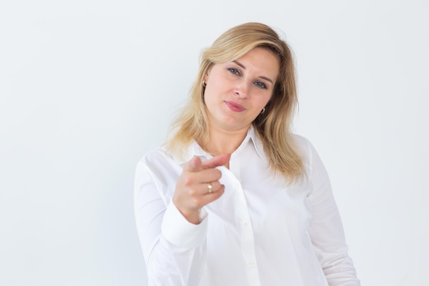 Its you Beautiful woman company manager pointing finger at camera and smiling choosing and inviting people and recruiting standing over white background