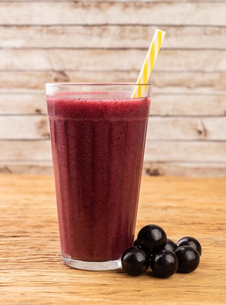 Jabuticaba juice with fruits over wooden table