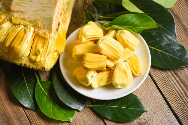 Jackfruit on white plate with leaf on wooden background, ripe jackfruit peeled tropical fruit fresh from jackfruit tree