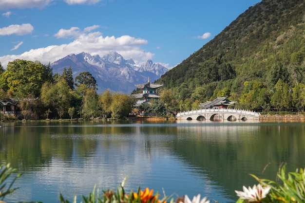 Jade Dragon Snow Mountain and the Suocui Bridge over the Black Dragon Pool in the Jade Spring Park, Lijiang, Yunnan province, China.