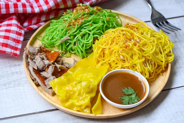 Jade noodle and yellow noodles Asian Thailand food roasted duck with jade noodle and pork dumplings on plate and duck sauce green noodles Chinese food