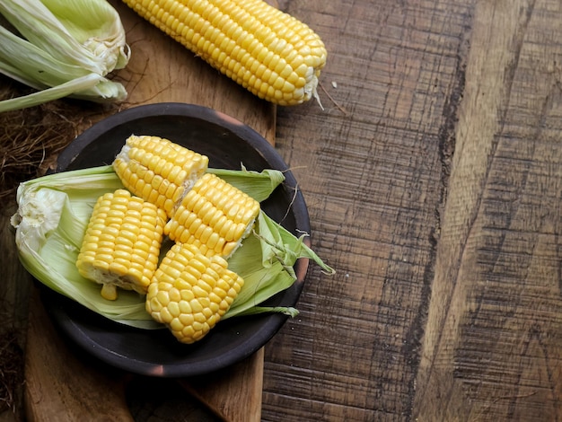 Jagung Manis Segar or fresh sweet corn on cobs on rustic wooden table