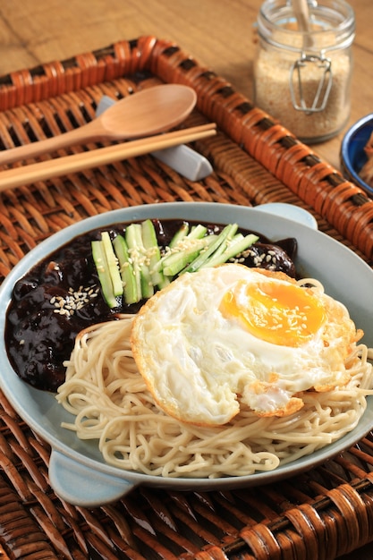 Jajang Myeon or JJajangmyeon Korean Noodle with Black Bean Sauce, Served with Cucumber and Sesame Seed