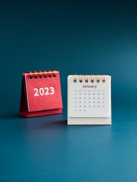 January 2023 calendar desk for the organizer to plan and reminder on blue background vertical style White table calendar with the first month near red cover with 2023 year numbers Happy new year