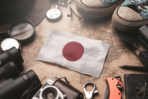 Japan Flag Between Traveler's Accessories on Old Vintage Map. Tourist Destination Concept.