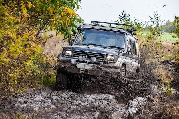 Japaneese SUV Toyota Land Cruiser Prado moving fast by deep mud