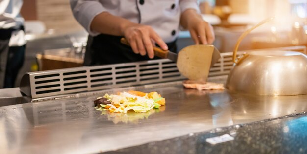 Japanese chef cooking meat in teppanyaki restaurant