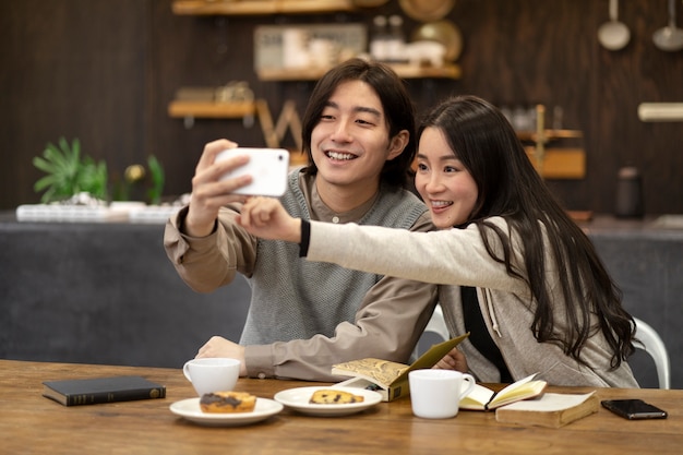 Japanese couple taking selfie in a restaurant