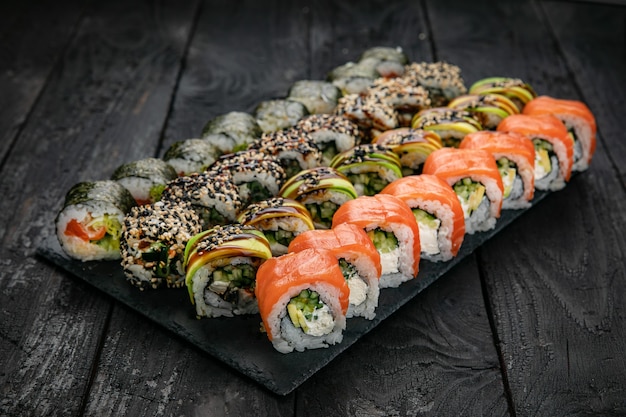 Japanese cuisine Rolls with salmon tuna on a black table