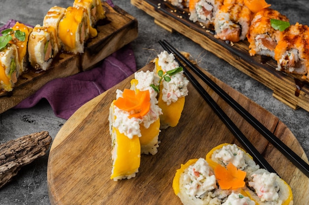 Japanese cuisine. Sushi roll with mango and crab in wooden plate