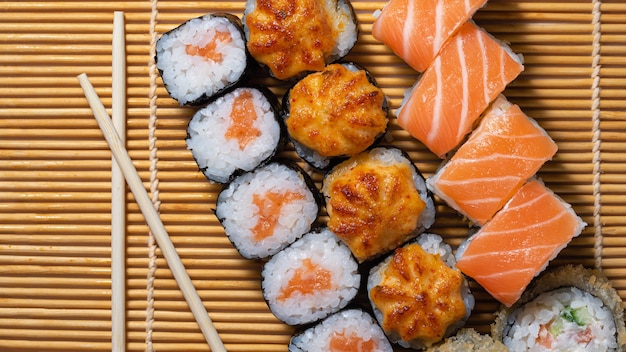 Japanese cuisine sushi rolls set on a bamboo mat top view