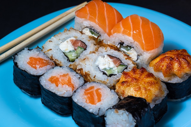 Japanese cuisine sushi rolls set on a blue plate