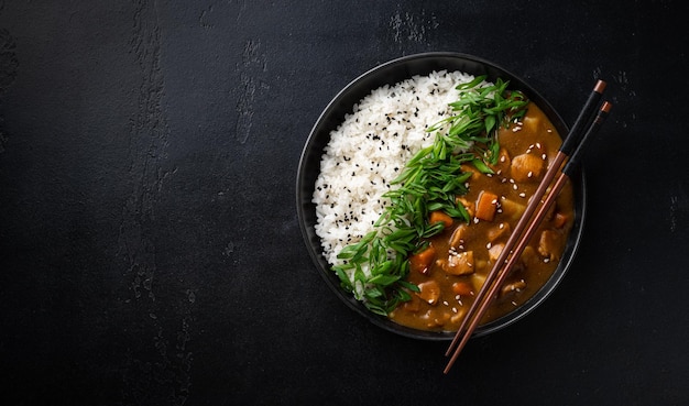 Japanese curry with rice on a black background view from above copy space