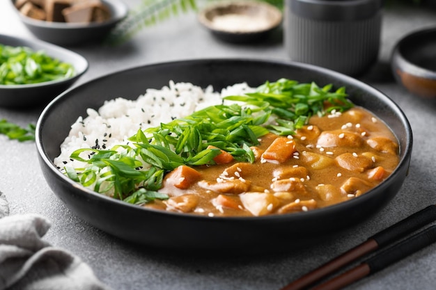 Japanese curry with rice in a black ceramic plate selective focus