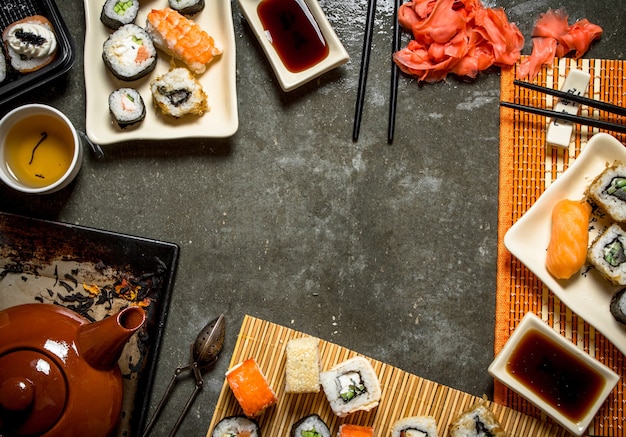 Japanese food. Fragrant tea , sushi and rolls with pickled ginger and soy sauce.