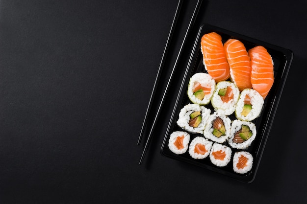 Japanese food: maki and nigiri sushi set on black background top view copy space