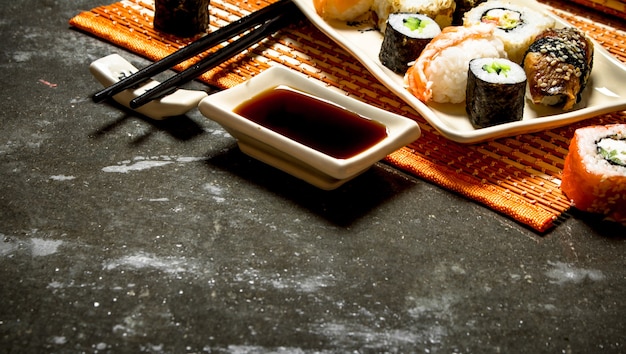 Japanese food . The rolls and sushi with soy sauce on bamboo stand.