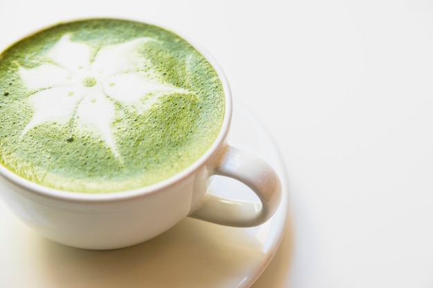 Japanese green tea latte in white cup against white background