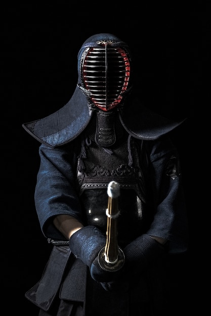 Japanese kendo fighter with with shinai on a black background