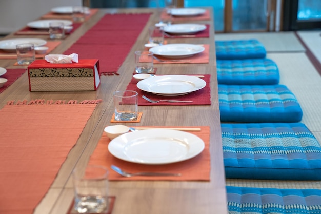 Japanese modern applied dining room style with eastern dish fork spoon napkin and glass on the table