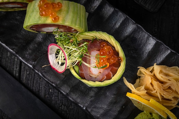 Japanese rolls on a dark plate in a restaurant