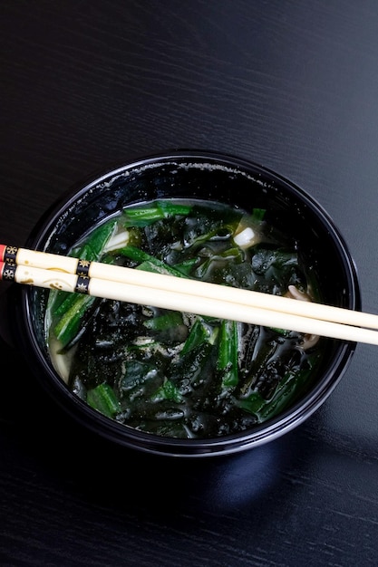 Japanese soup and sticks on wooden table