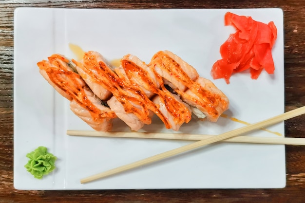 Japanese sushi and rolls on a japanese wooden table with wasabi sauce