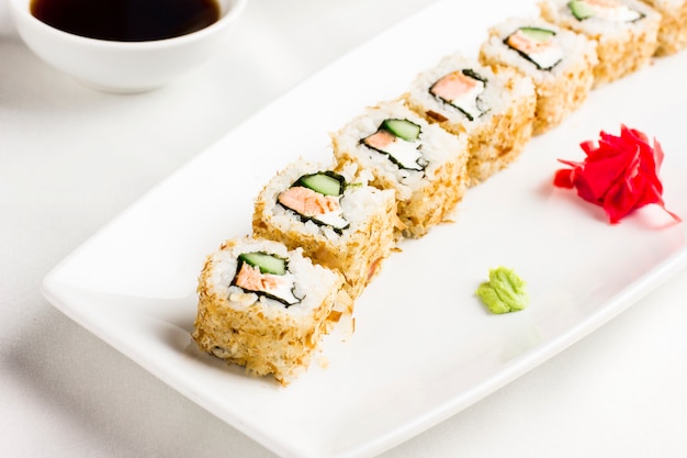 Japanese sushi rolls with salmon and cucumber avocado on white background